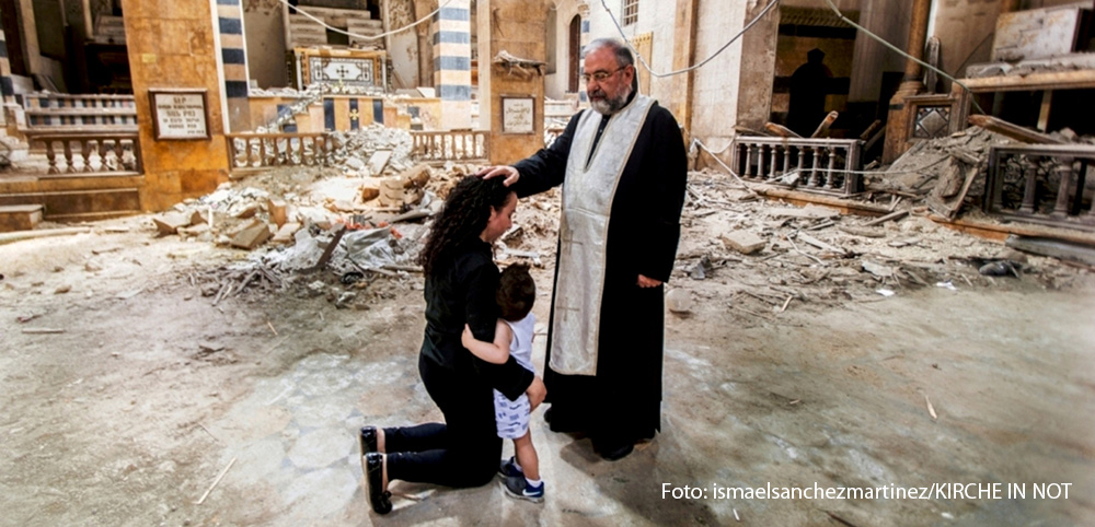 4-bischof-segnet-mutter-mit-kind-in-zerstoerter-kathedrale-in-aleppo